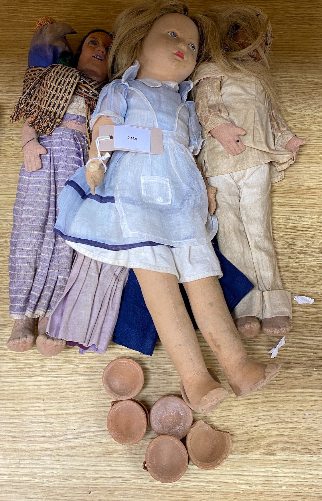 A Farnell’s Alpha Toys felt doll, 46cm, three Mexican souvenir cloth dolls and various clay toy dishes